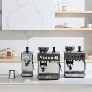 Tre avancerade espressomaskiner i ett modernt kök.