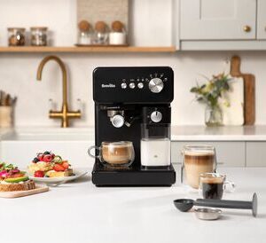 Svart espressomaskin med färdiga kaffedrycker i modernt kök.