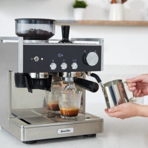 Espressomaskin brygger kaffe i modernt kök.